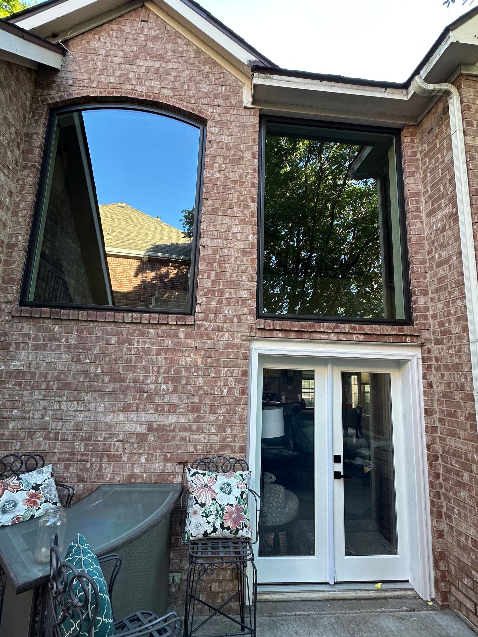 A brick house with a large window and a sliding glass door