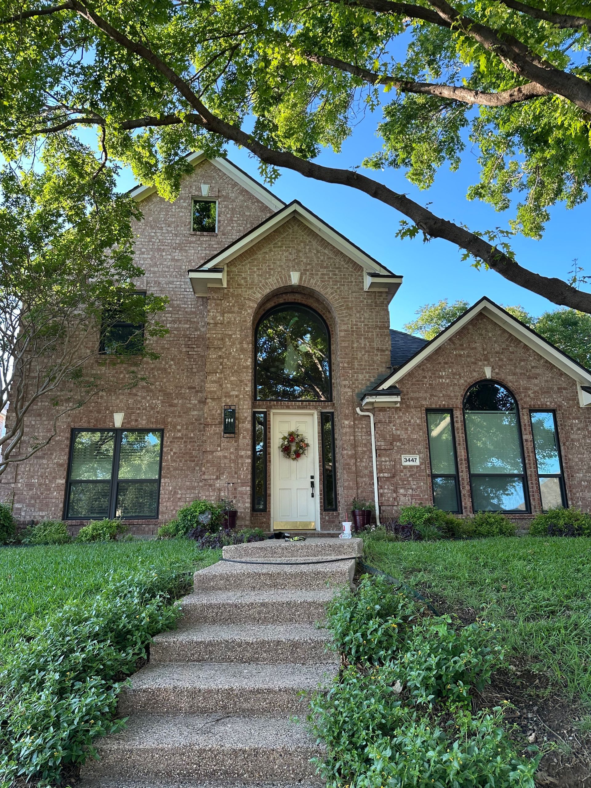 A large brick house with stairs leading up to the front door.