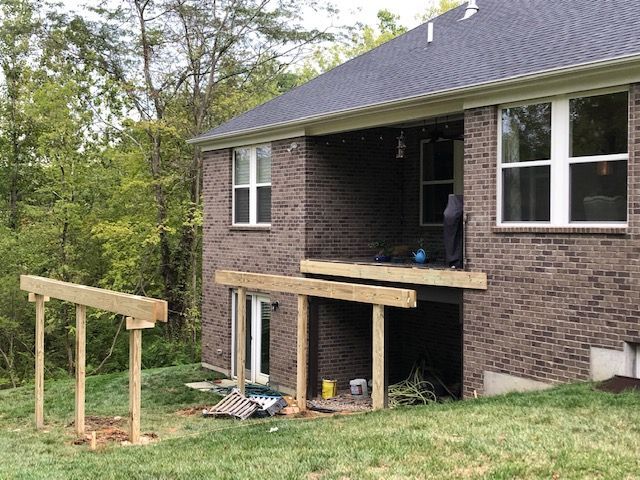 House exterior with a newly built wooden porch ramp and steps in a grassy yard