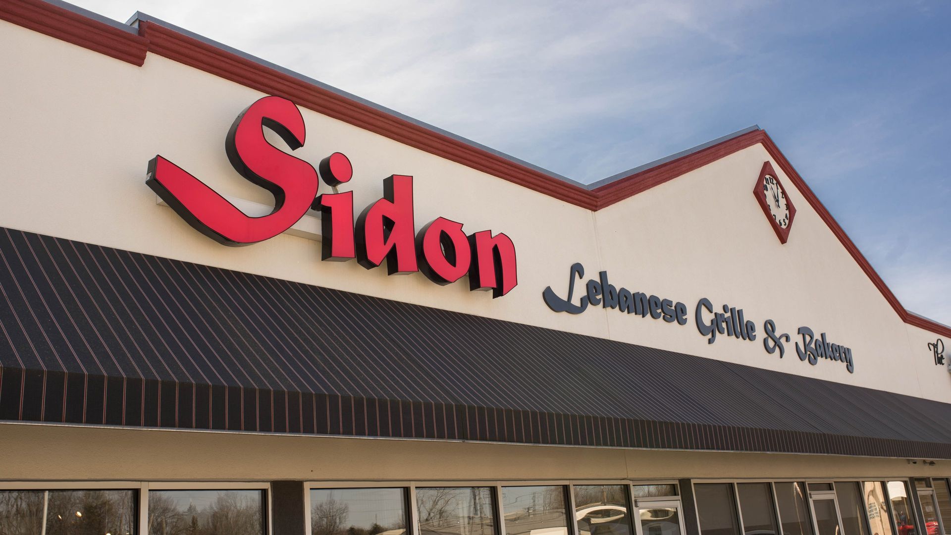 Sidon Lebanese Grill sign in red, above a storefront.