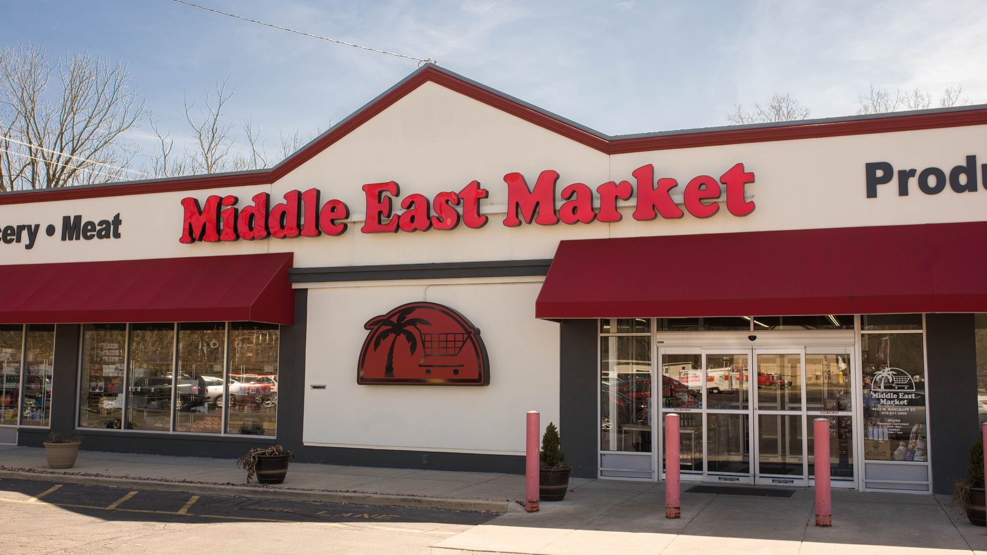 Middle East Market storefront with red awnings, sign, and door.
