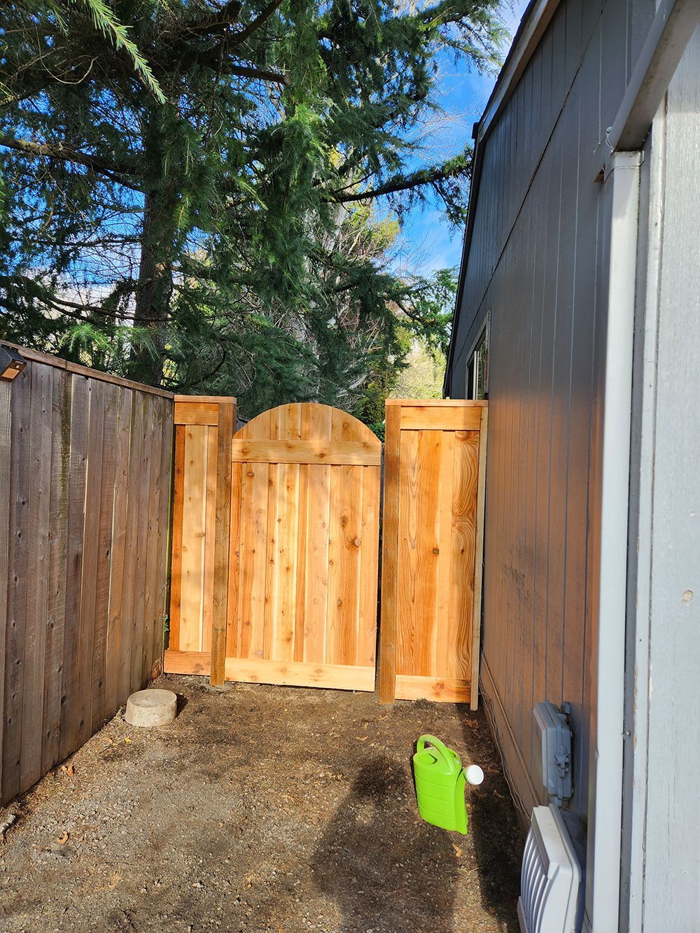 A wooden fence with a gate in the backyard of a house