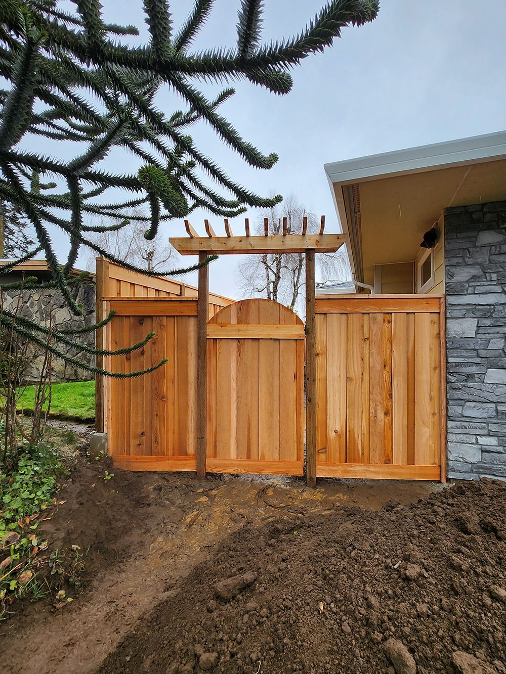 A wooden fence with a gate in front of a house