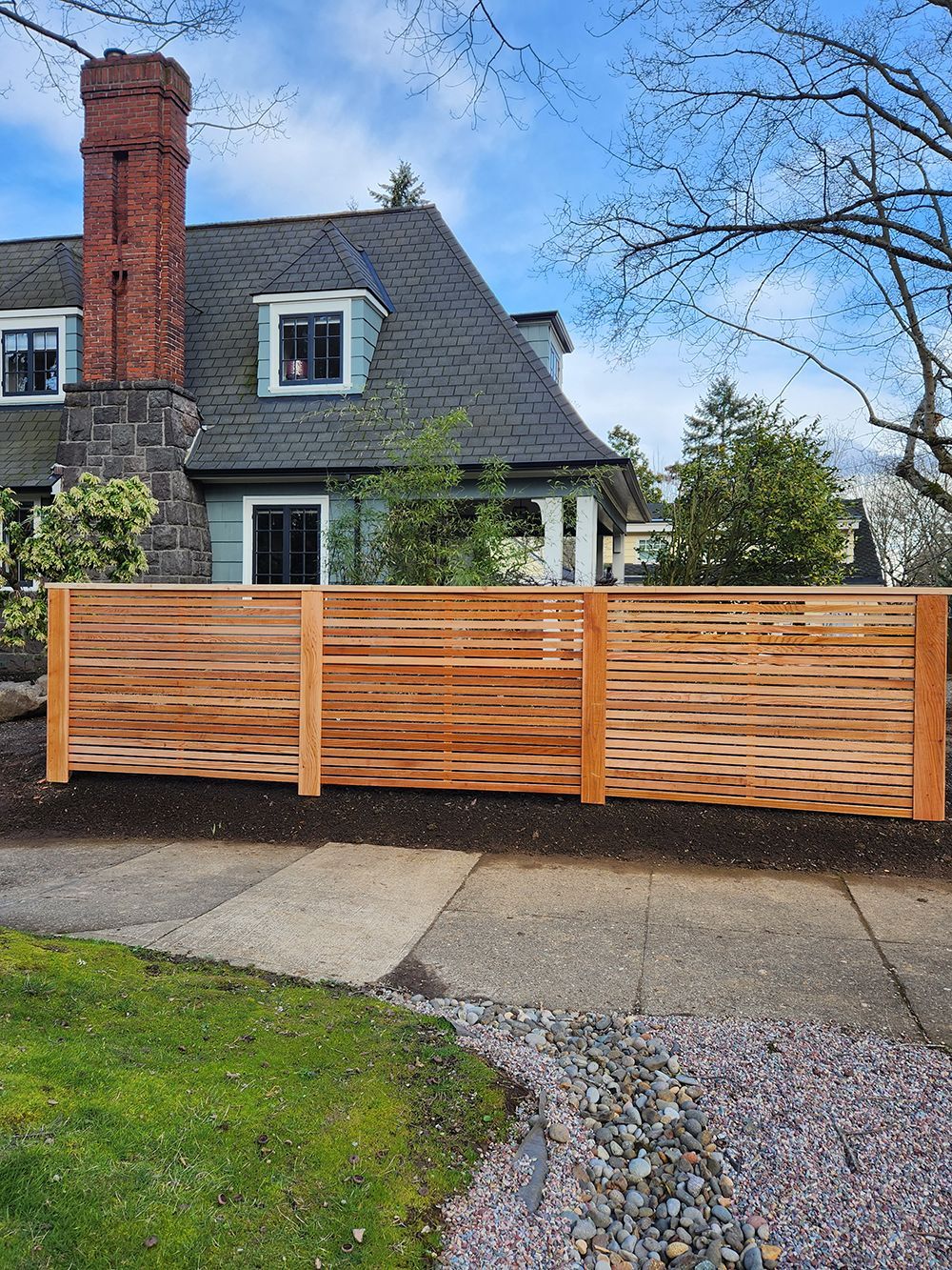A wooden fence is sitting in front of a house