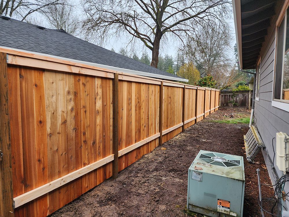 A wooden fence is in the backyard of a house
