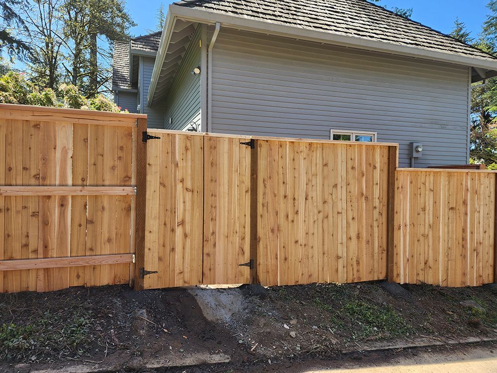 A wooden fence with a gate in front of a house
