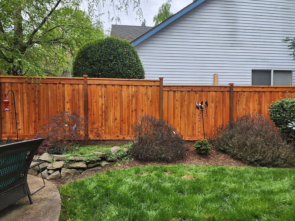 A wooden fence is in the backyard of a house