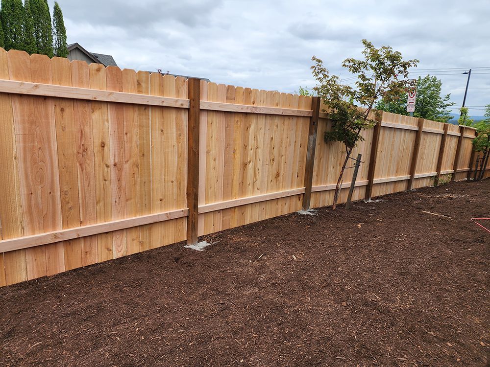 A wooden fence is sitting in the middle of a dirt field