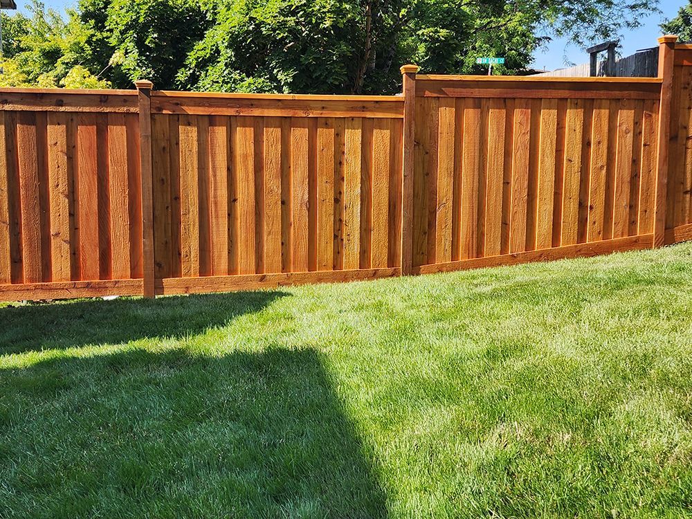A wooden fence is sitting on top of a lush green lawn
