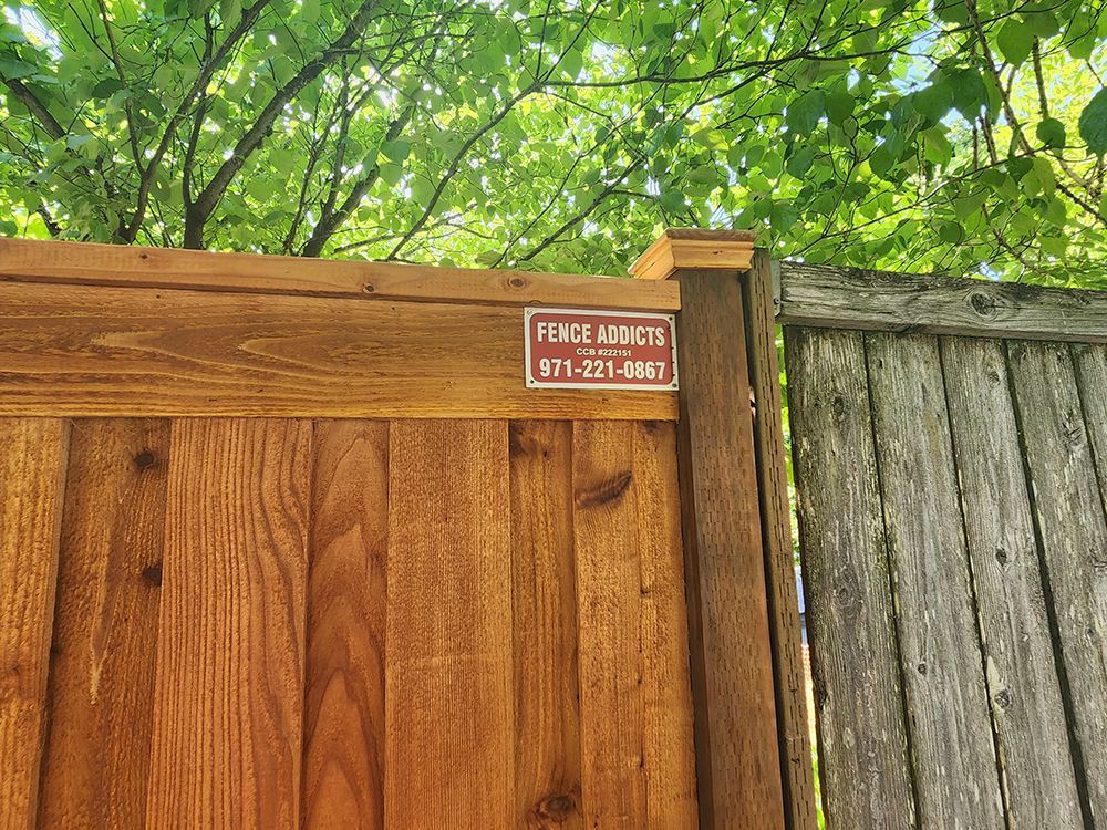A wooden fence with a sticker on it that says fence experts