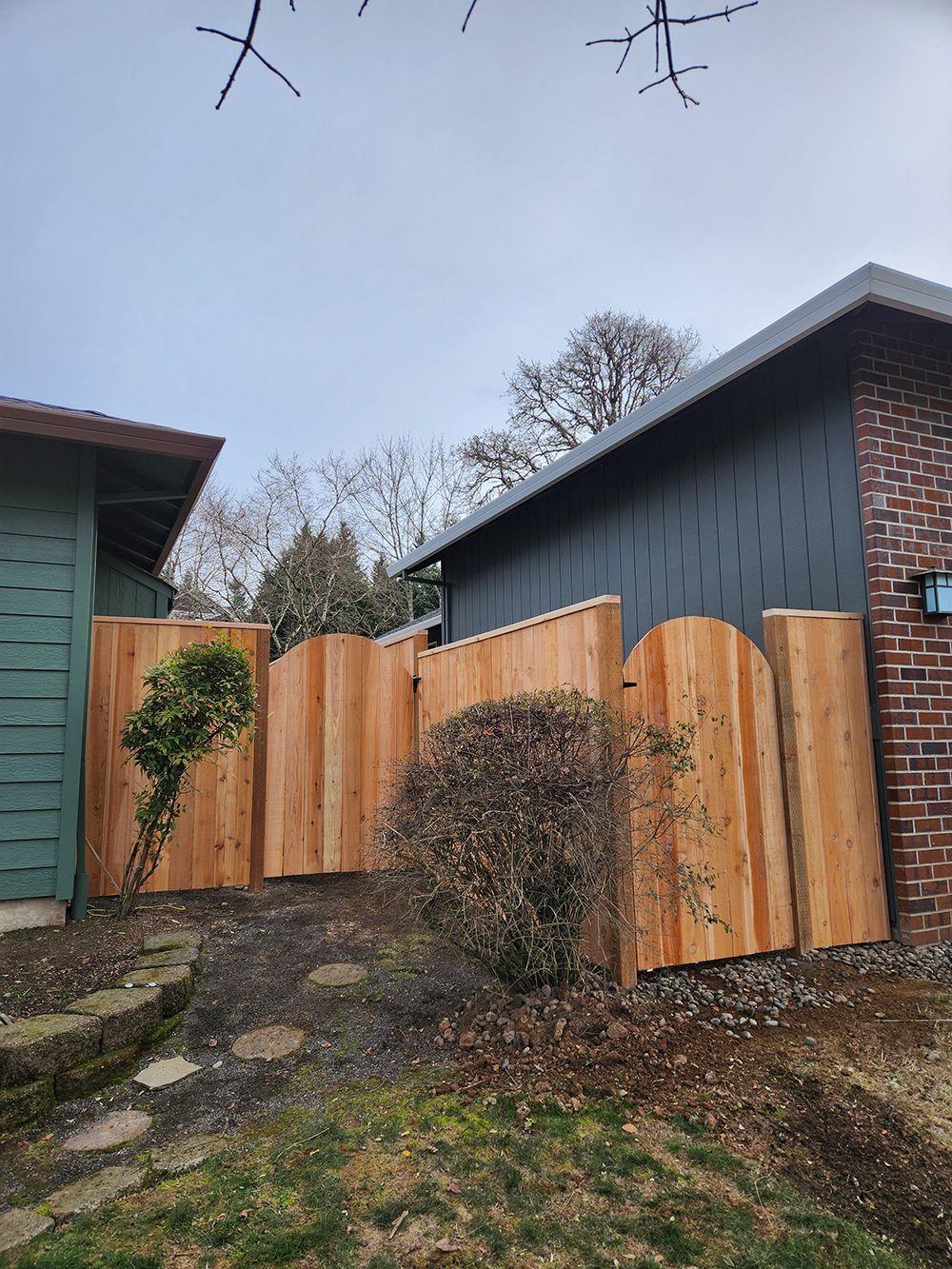 A wooden fence is in the backyard of a house