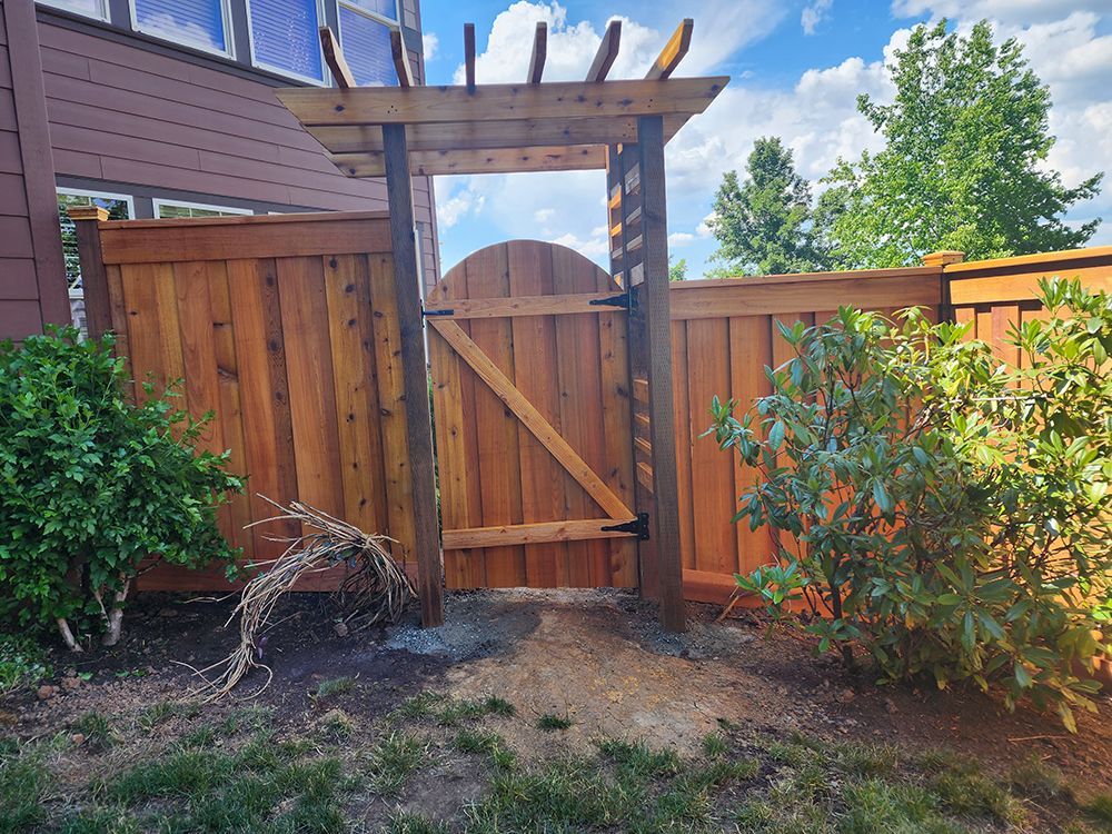 A wooden fence with a gate in the middle of it