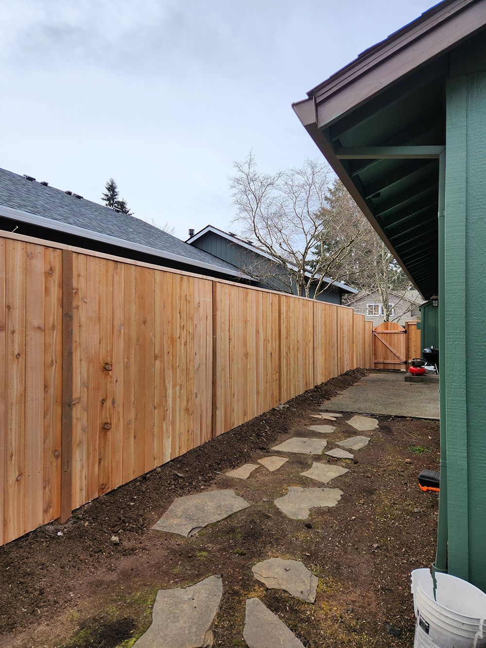 A wooden fence is in the backyard of a house