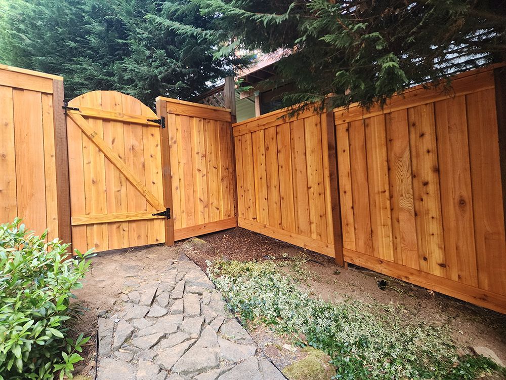 A wooden fence with a gate in the backyard