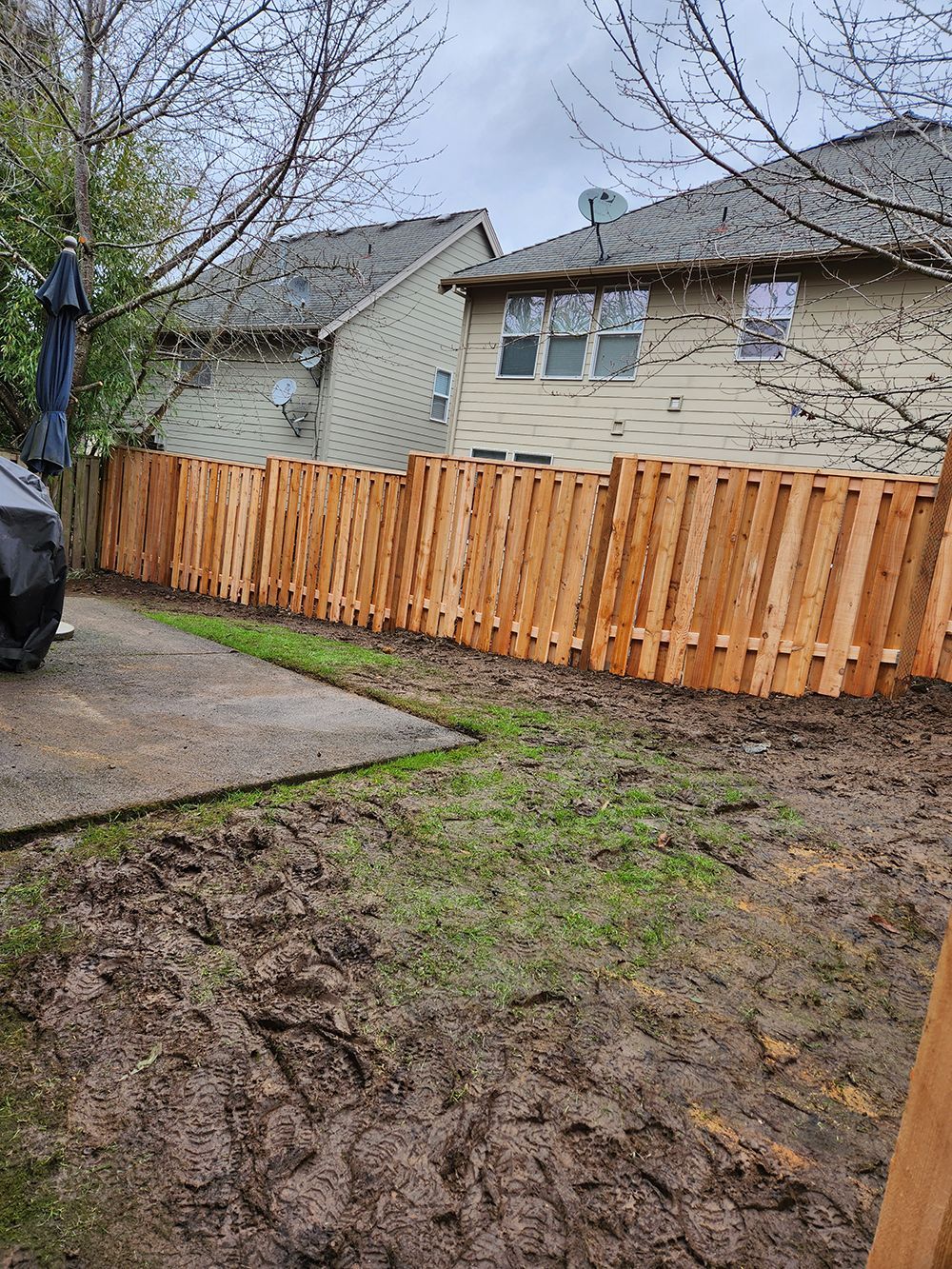 A wooden fence is in the backyard of a house