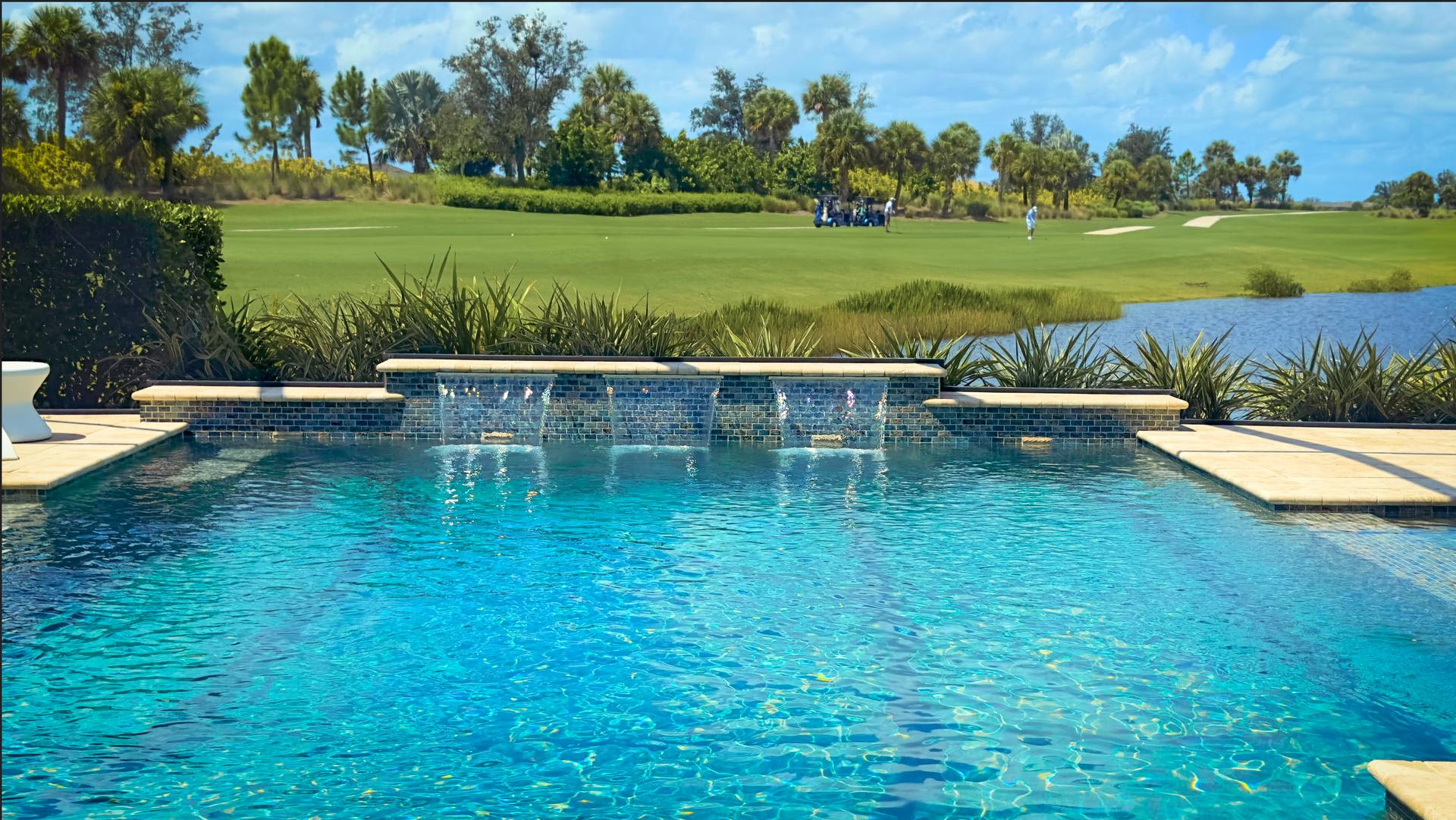 A large swimming pool with a golf course in the background