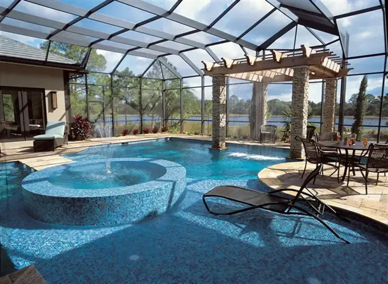 A large indoor swimming pool with a screened in area