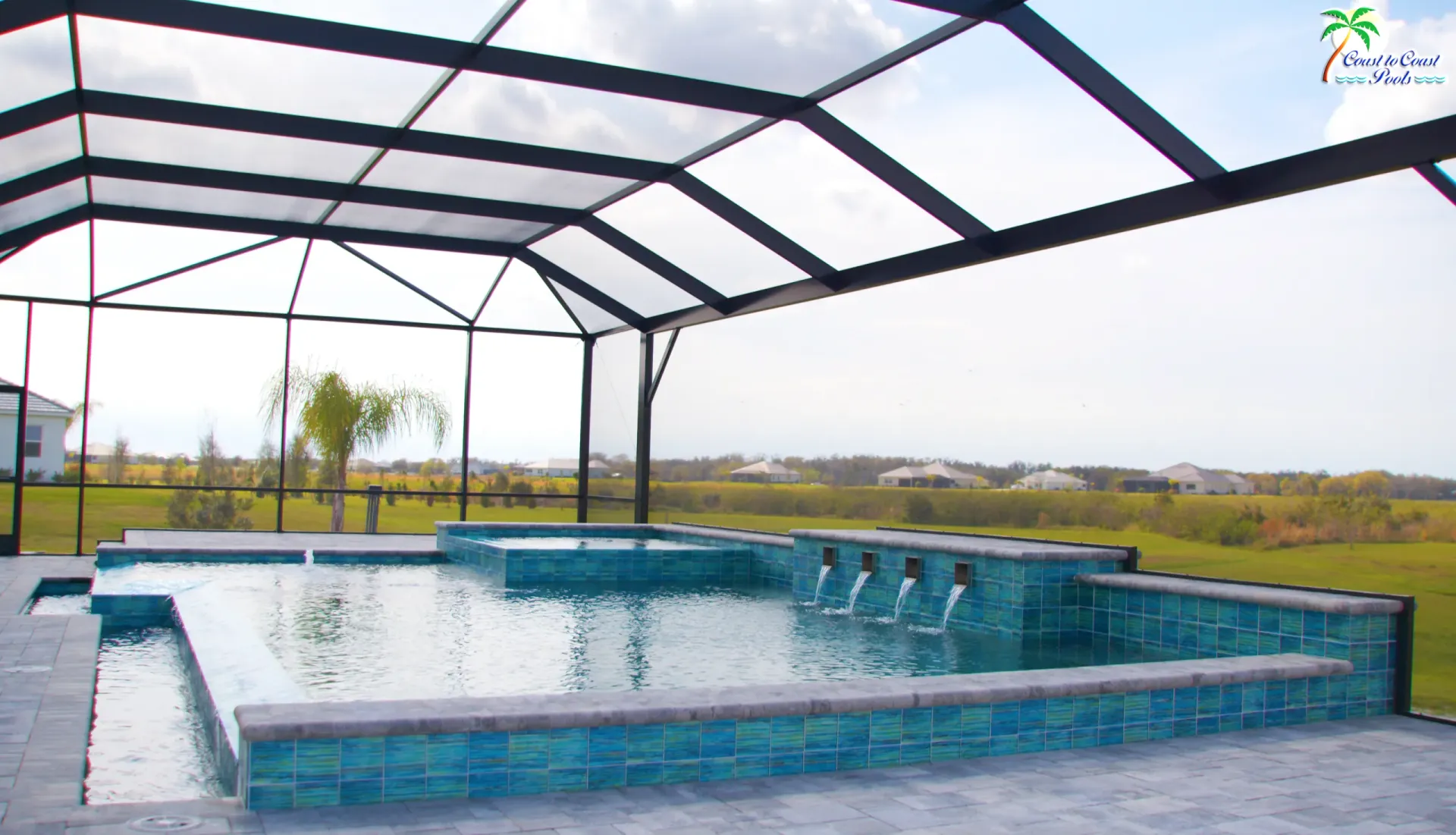 A screened in swimming pool with a palm tree in the background