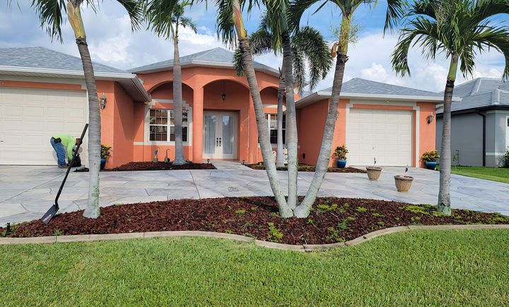 A house with a lot of palm trees in front of it.