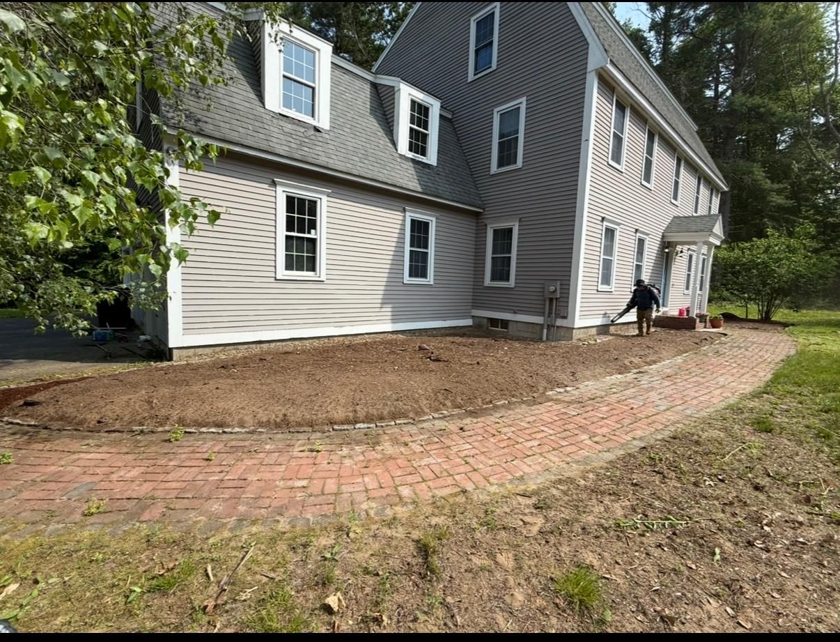 House exterior with a curved brick walkway and a person near the side door