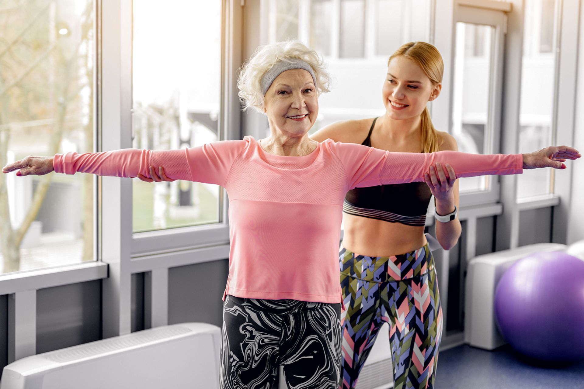 senior female balance exercise with trainer