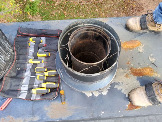 A person is standing next to a tool bag with screwdrivers on it