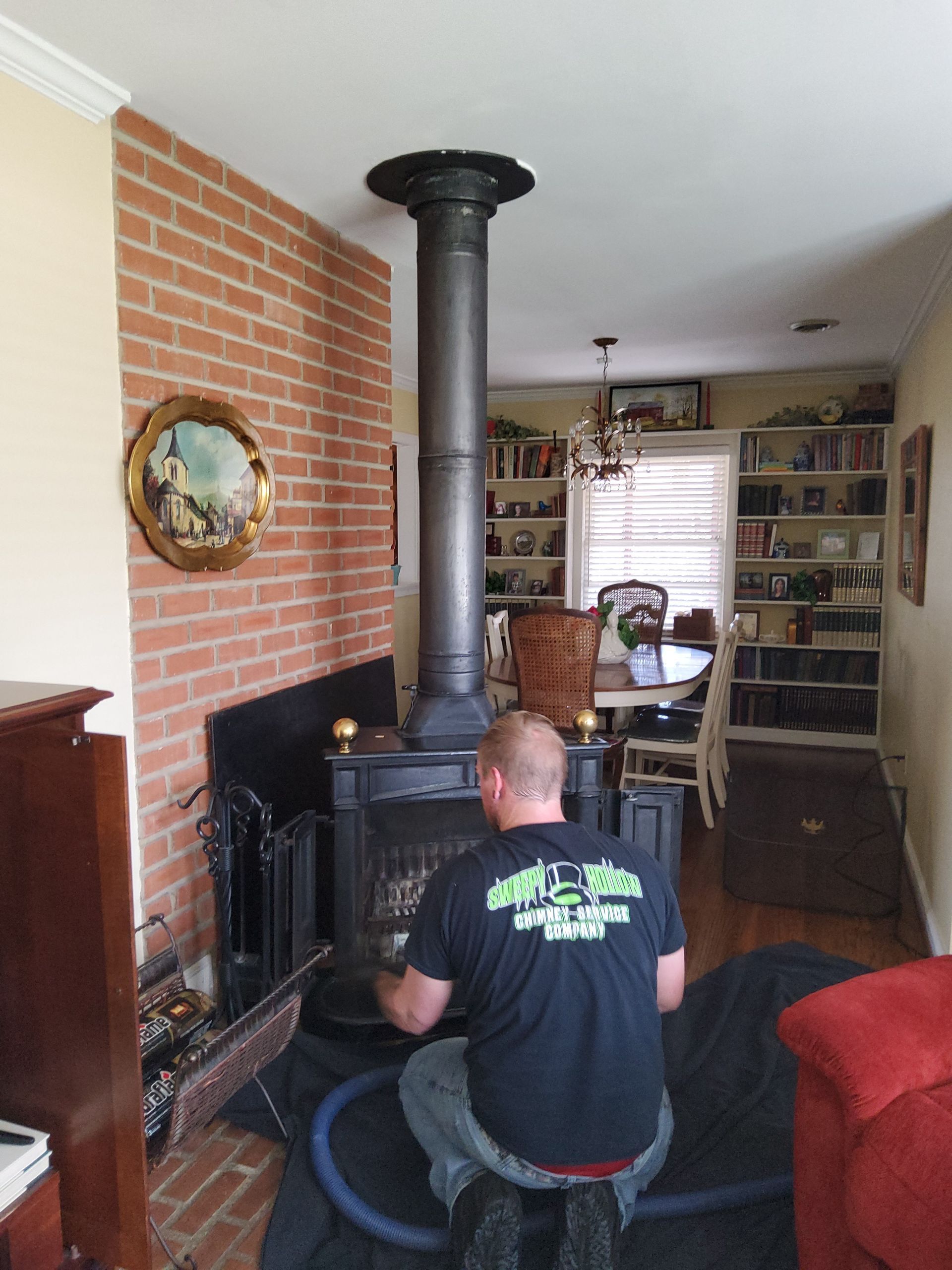 A man is kneeling in front of a fireplace in a living room