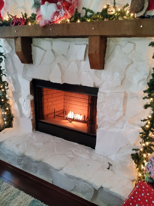A fireplace with a christmas tree in the background