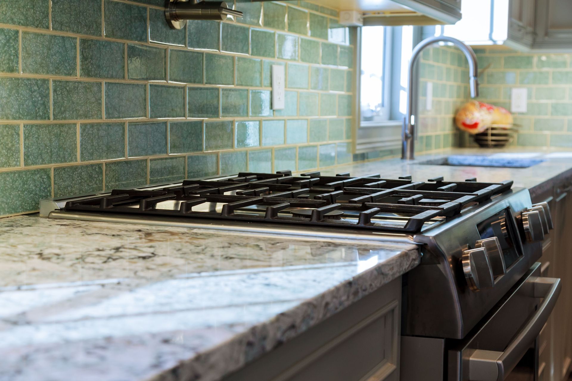 A stove top oven is sitting on top of a granite counter in a kitchen.