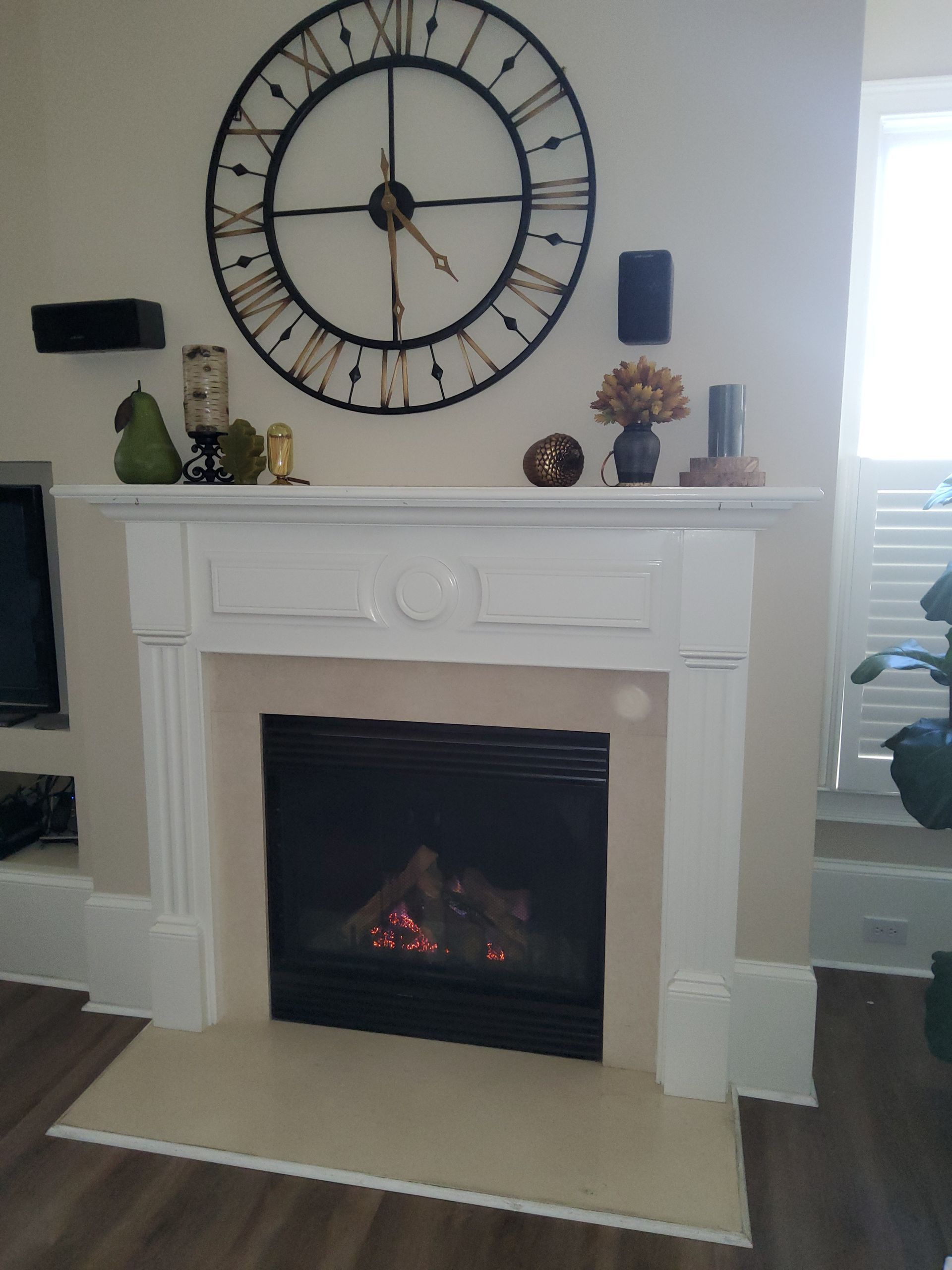 A fireplace with a clock on the wall above it