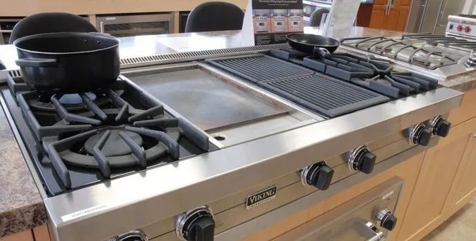 A stove with a pot on top of it in a kitchen.