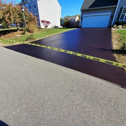 A driveway with a yellow caution tape along the side of it.