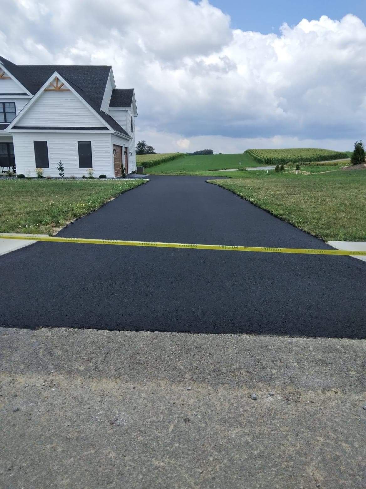 A driveway leading to a house with a yellow tape on it
