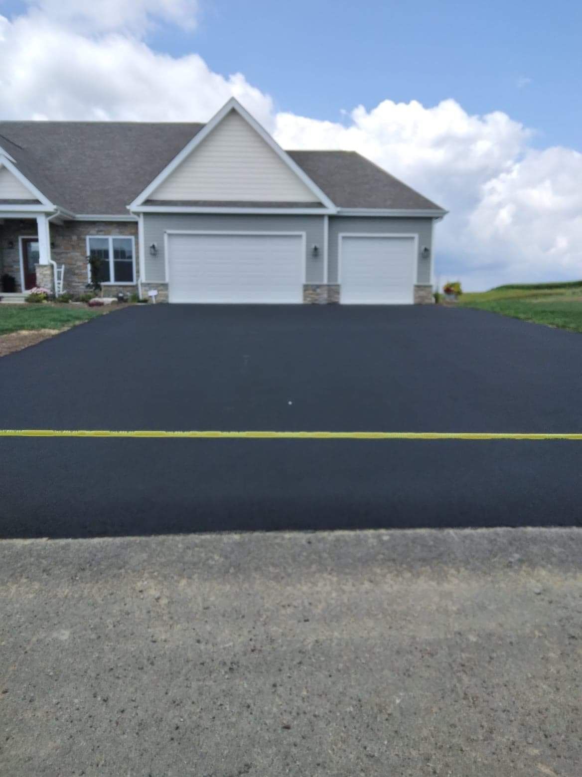 A house with a large driveway in front of it
