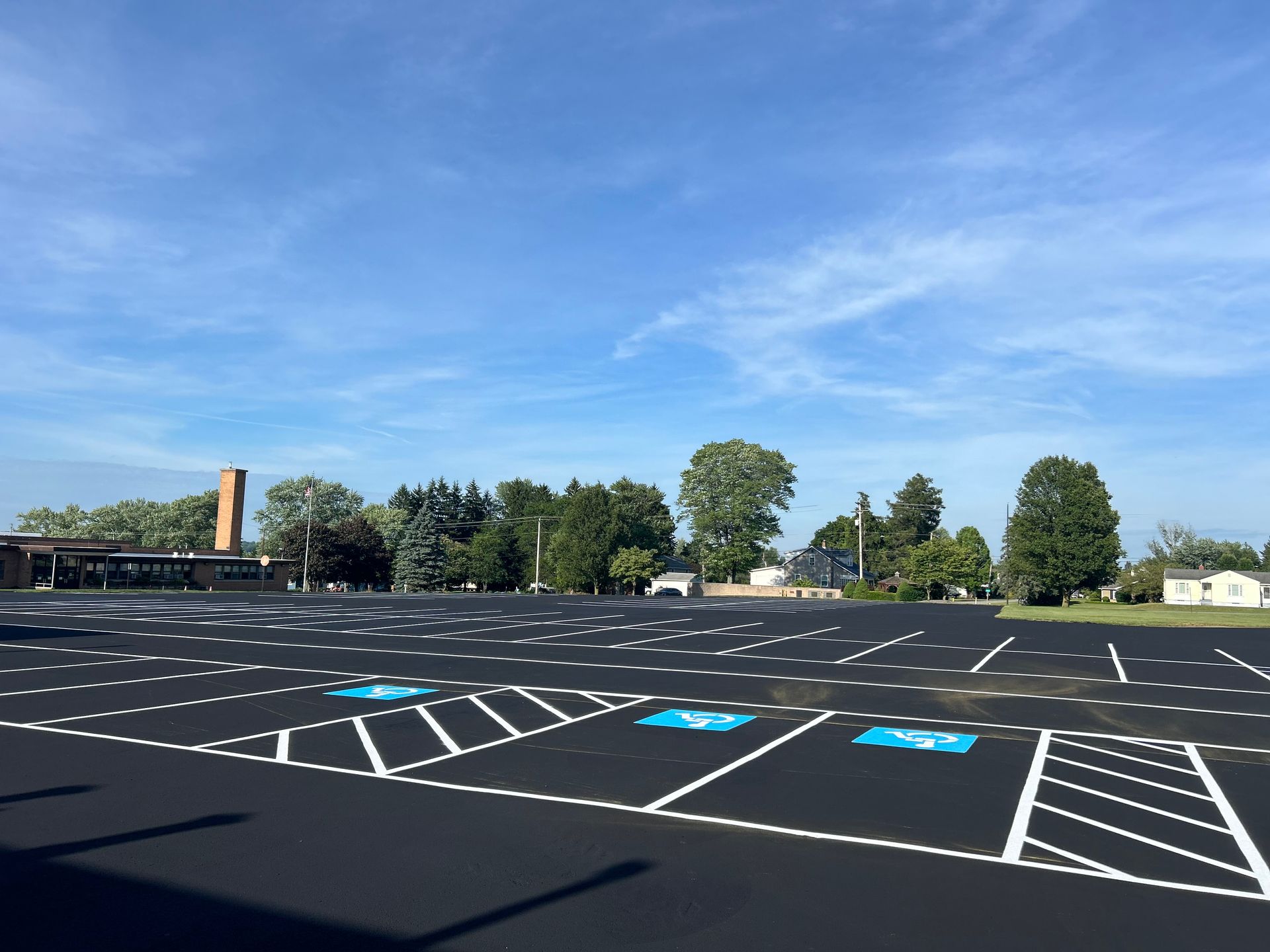 An empty parking lot with a blue handicap sign in the middle