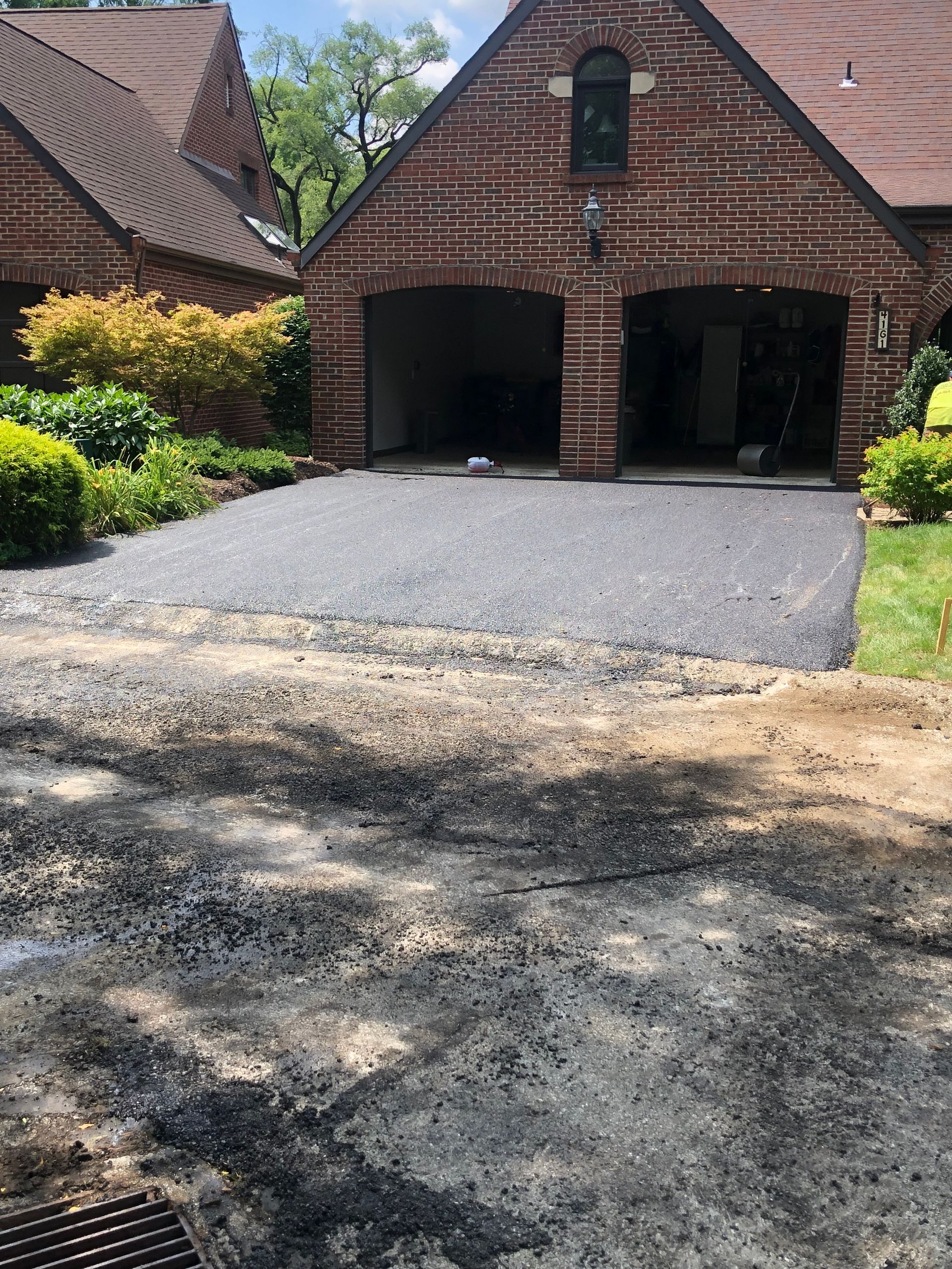 A brick house with a driveway in front of it.