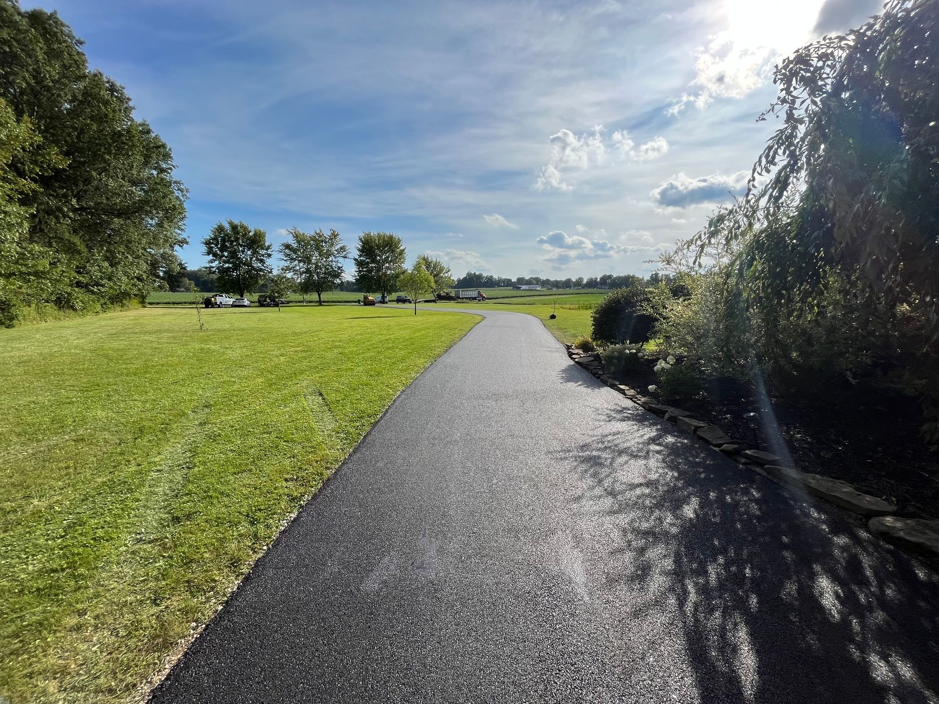A path going through a grassy field with trees on both sides