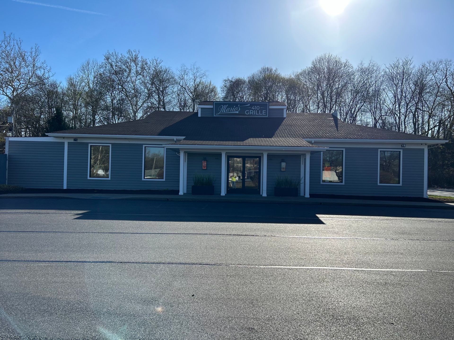 A large building with a lot of windows is sitting on the side of the road.