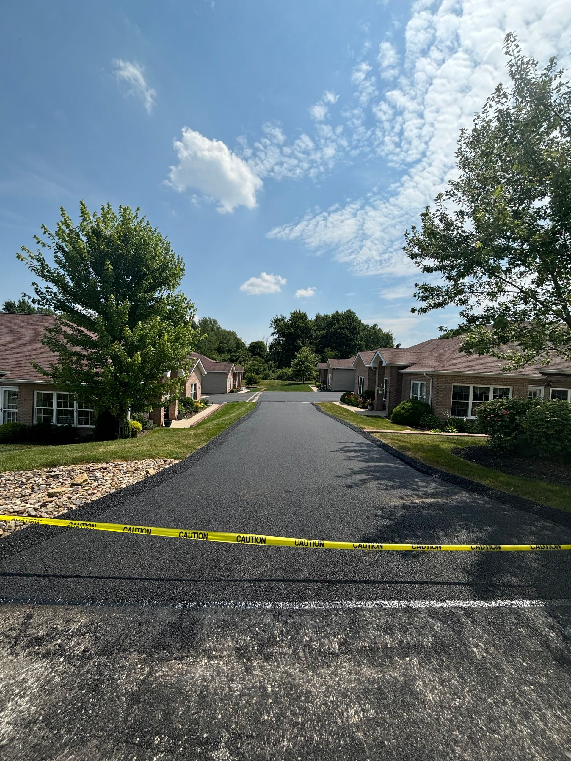 A residential street with a yellow tape on the side of it.