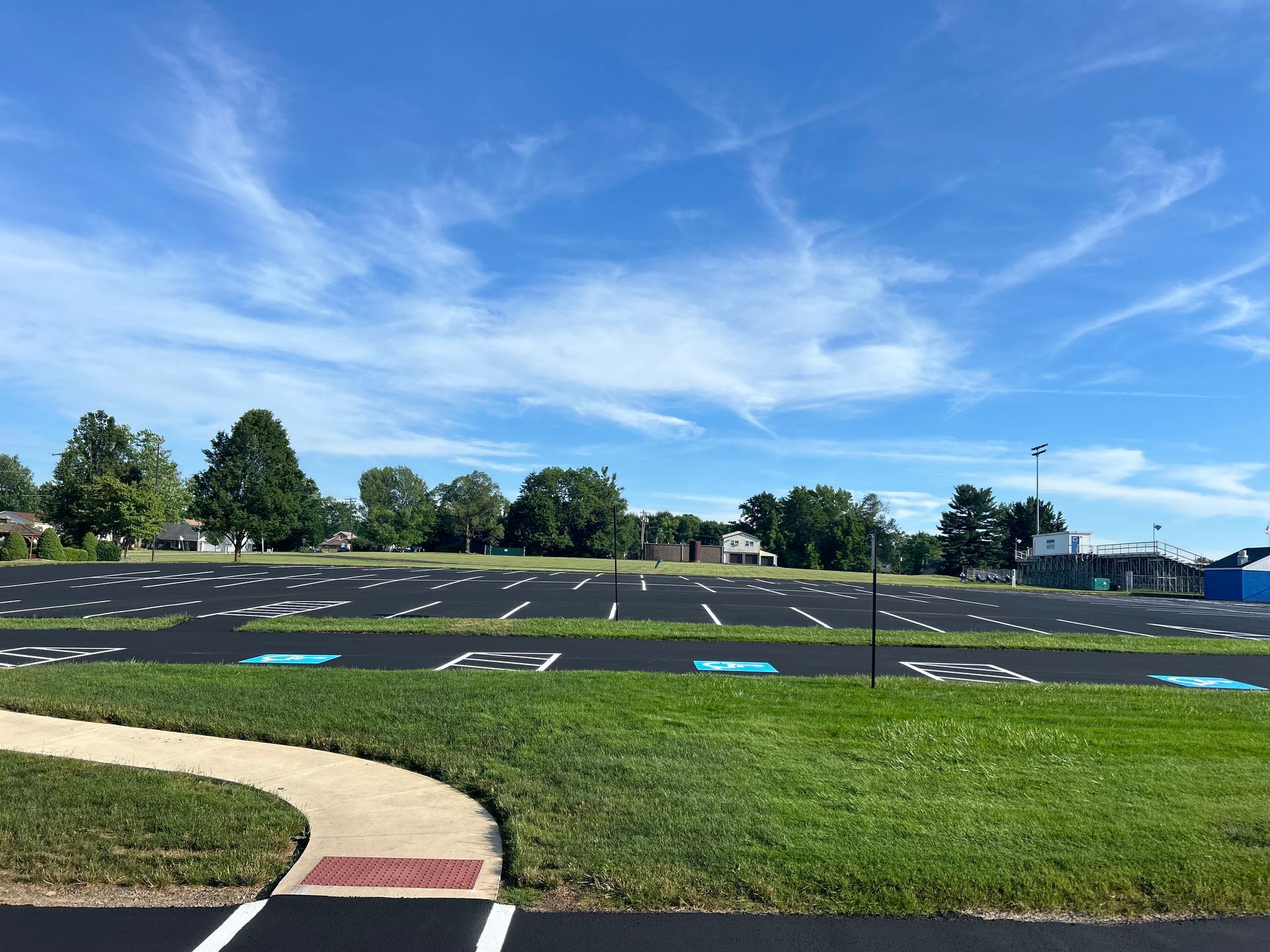 A parking lot with a path going through it on a sunny day.