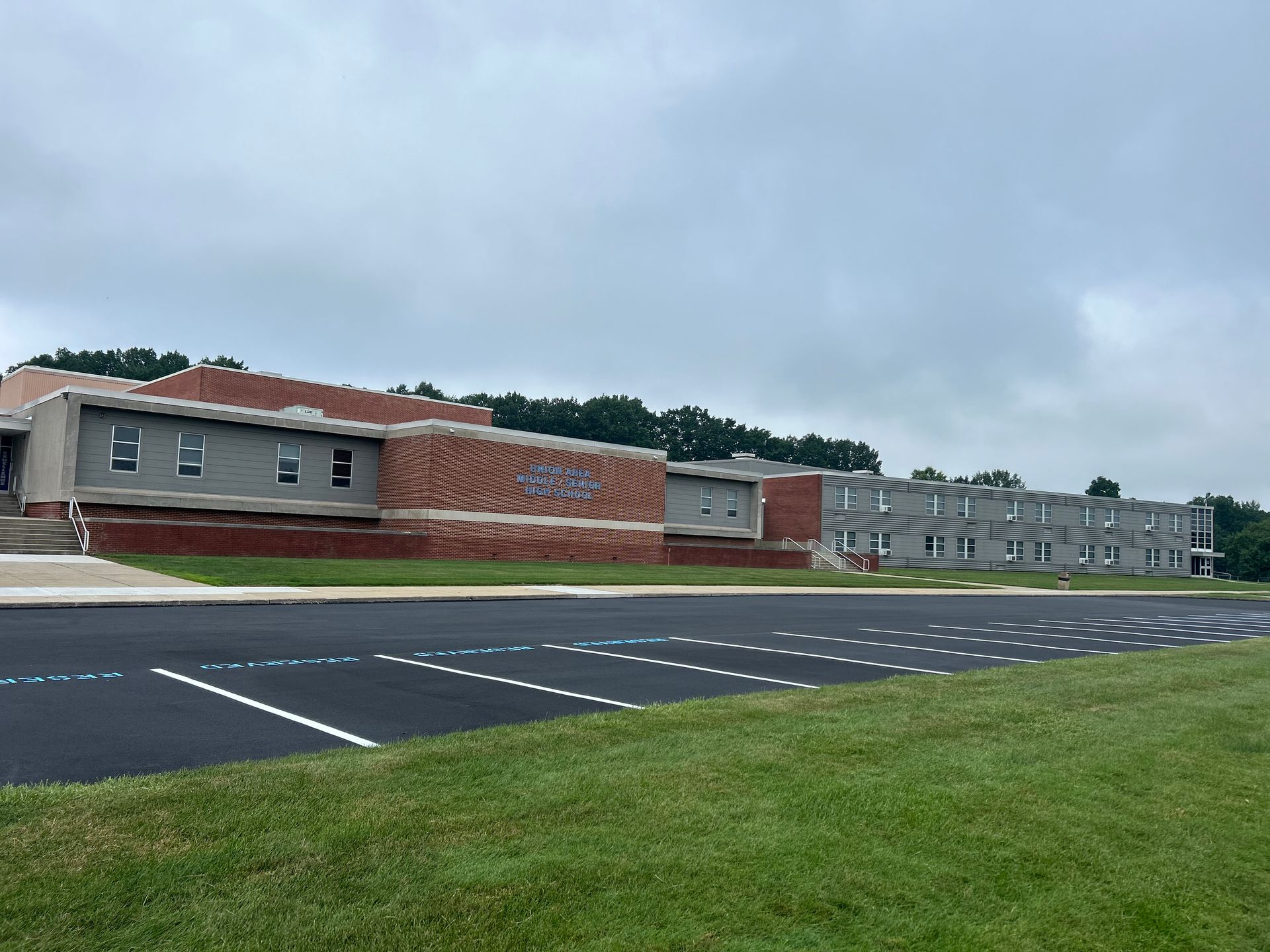 A large brick building with a parking lot in front of it.
