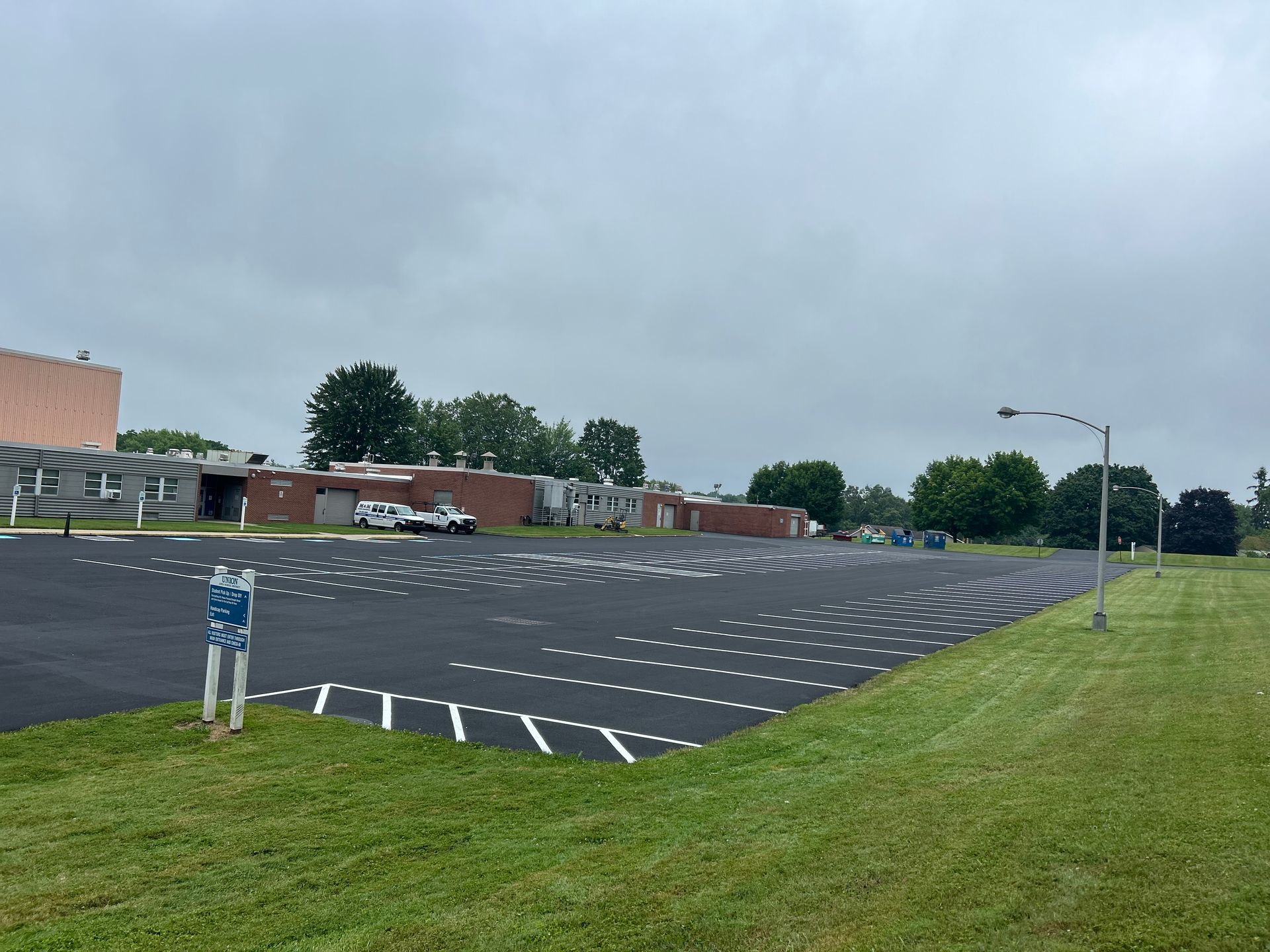 There is a large parking lot in front of a building.