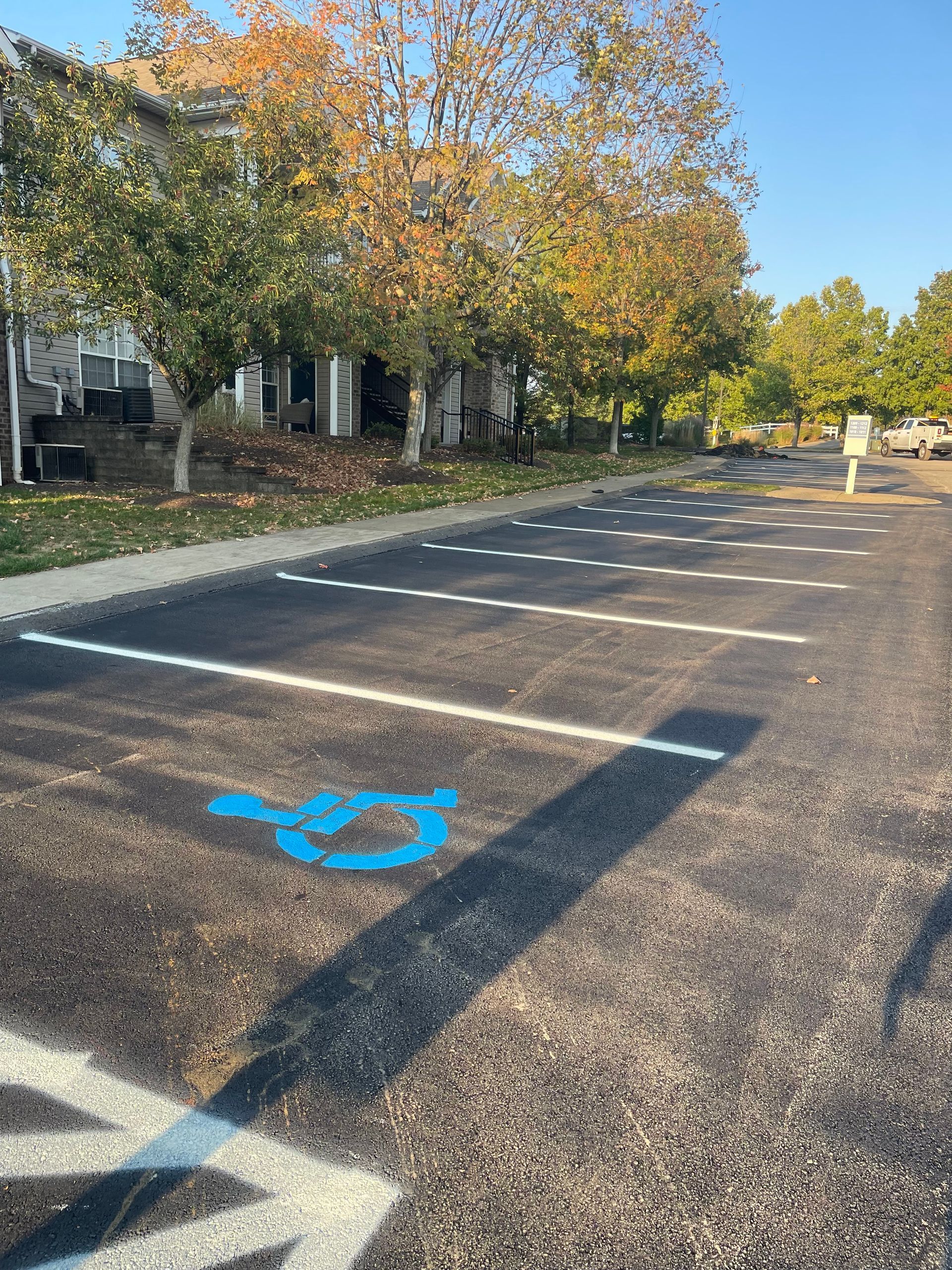 A handicapped parking spot is painted blue in a parking lot.