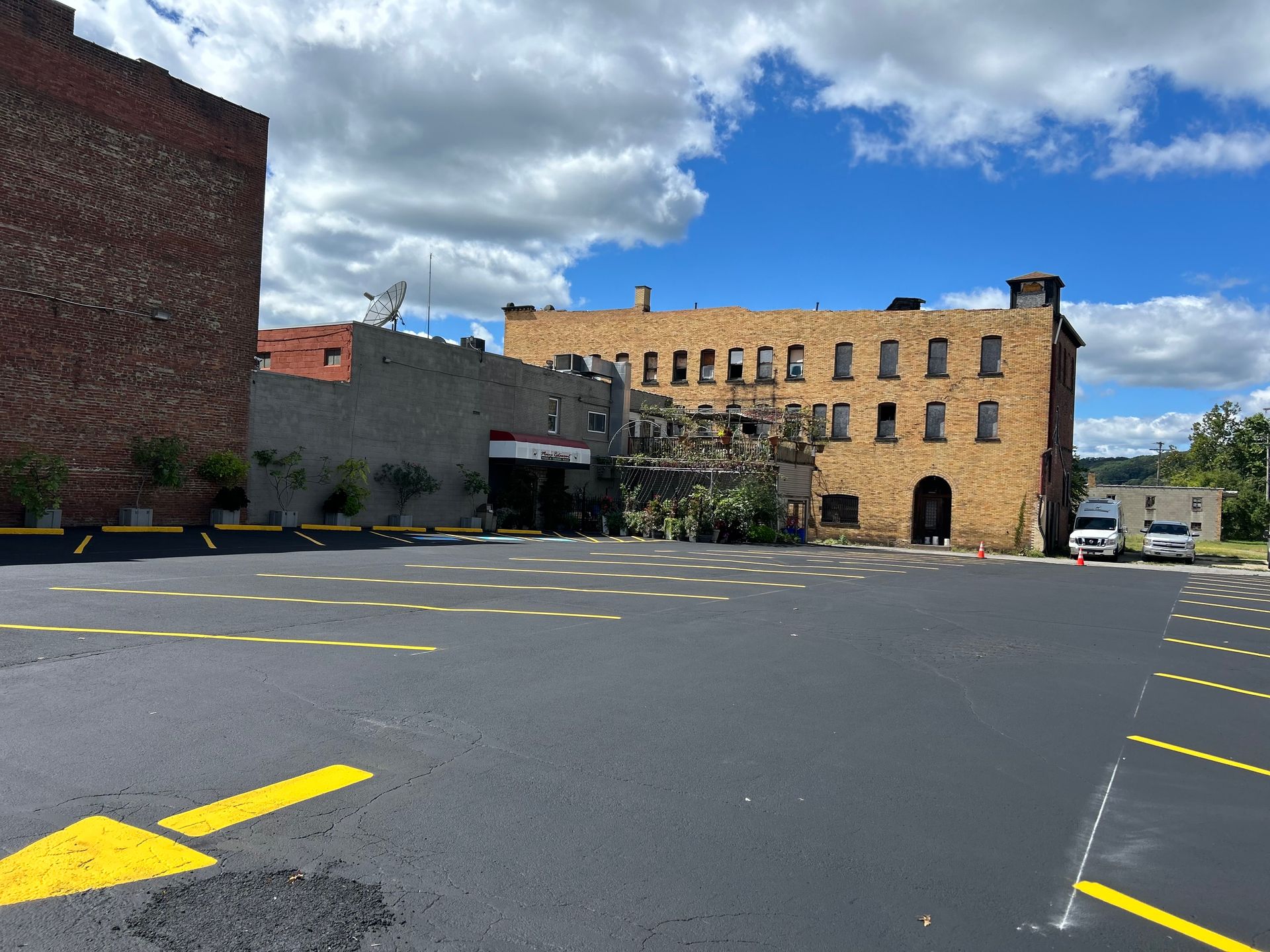 A parking lot with a brick building in the background