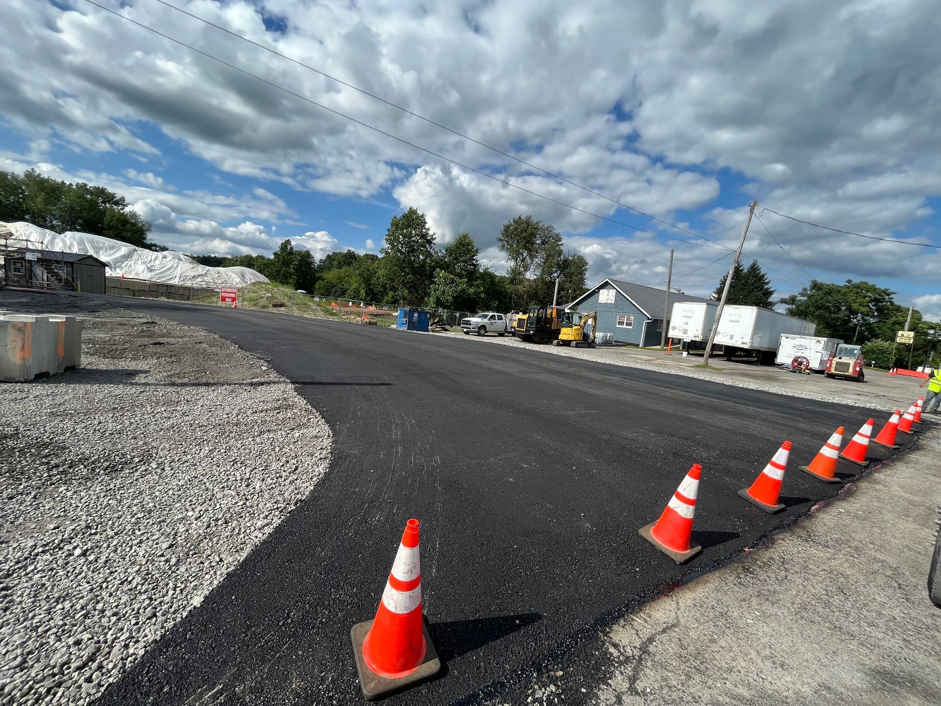 A row of orange and white traffic cones on the side of a road.