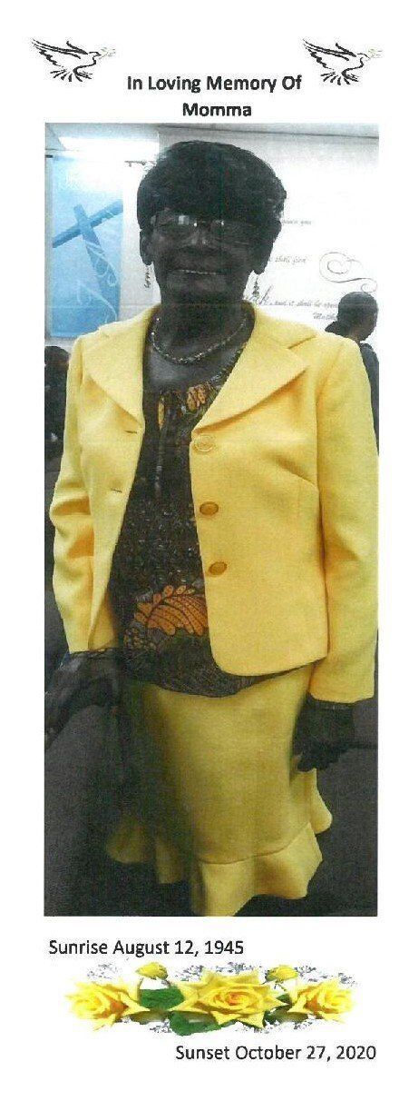Woman in a bright yellow suit standing indoors beside a wall poster.