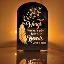 Warm amber memorial plaque with feather and birds, reading “Your wings were ready but our hearts were not.”