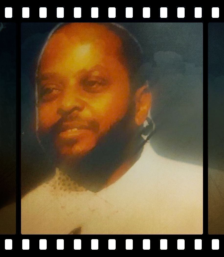 Portrait of a bearded man in a light shirt, softly lit with a warm, blurred background