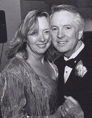 Smiling couple in formal attire posing together at an event