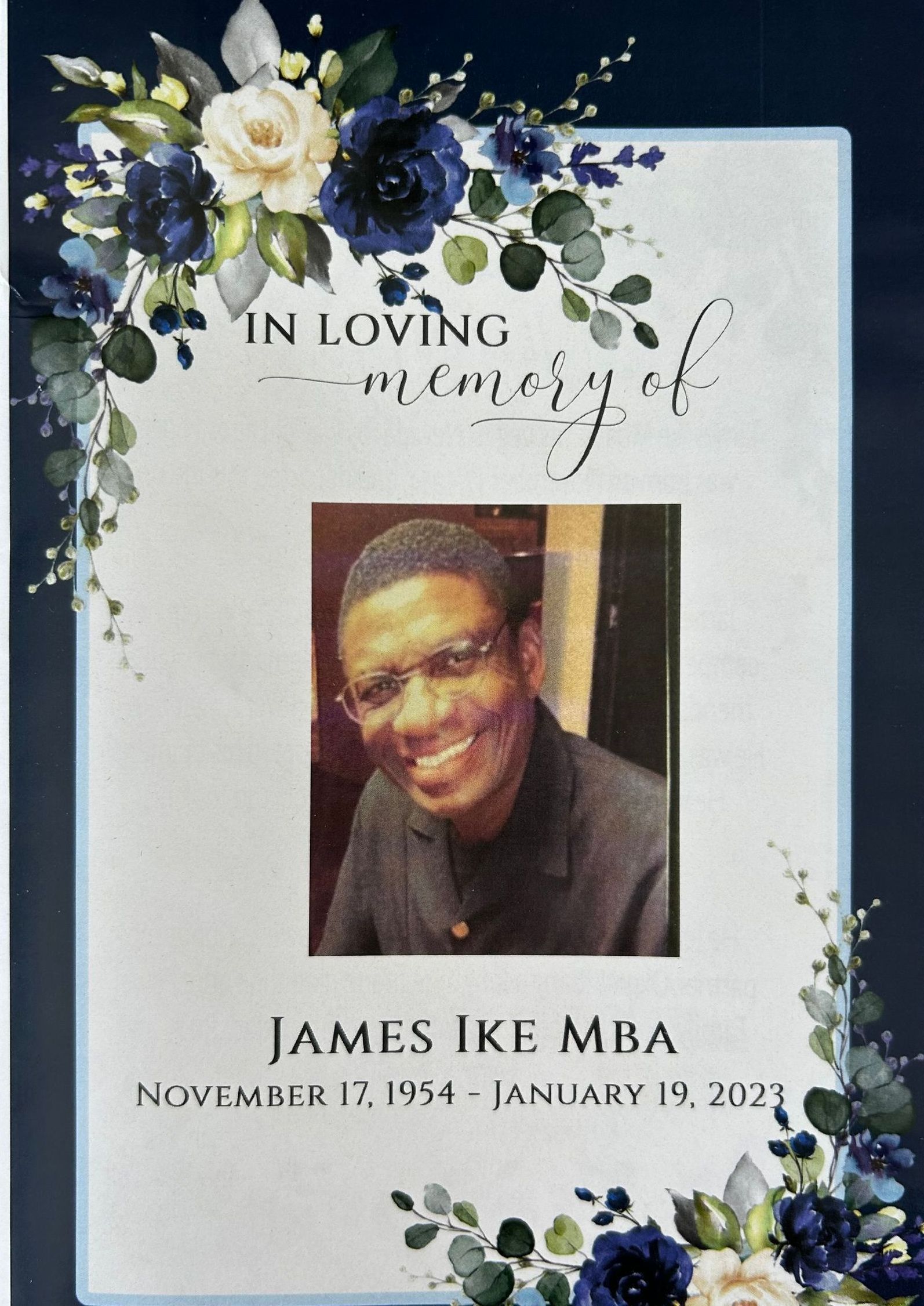 Memorial card with floral border and smiling portrait of James Ike Mba, with birth and death dates.